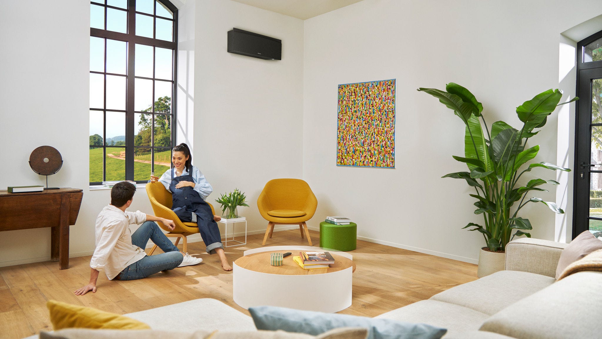Couple attendant un enfant discutant à l’aise, la femme assise sur une chaise.