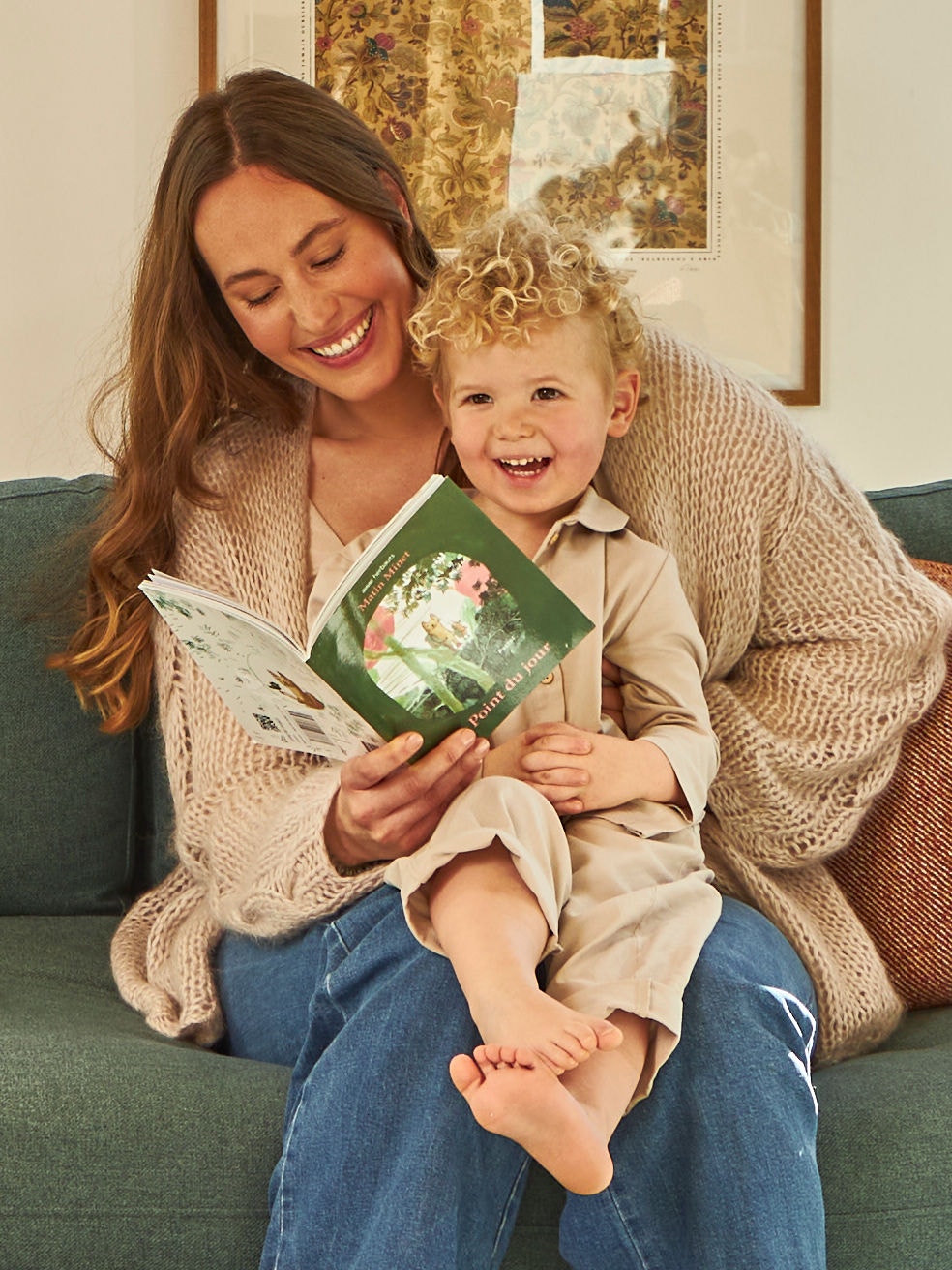 Mère et enfant en bas âge sur ses genoux regardant un petit livre