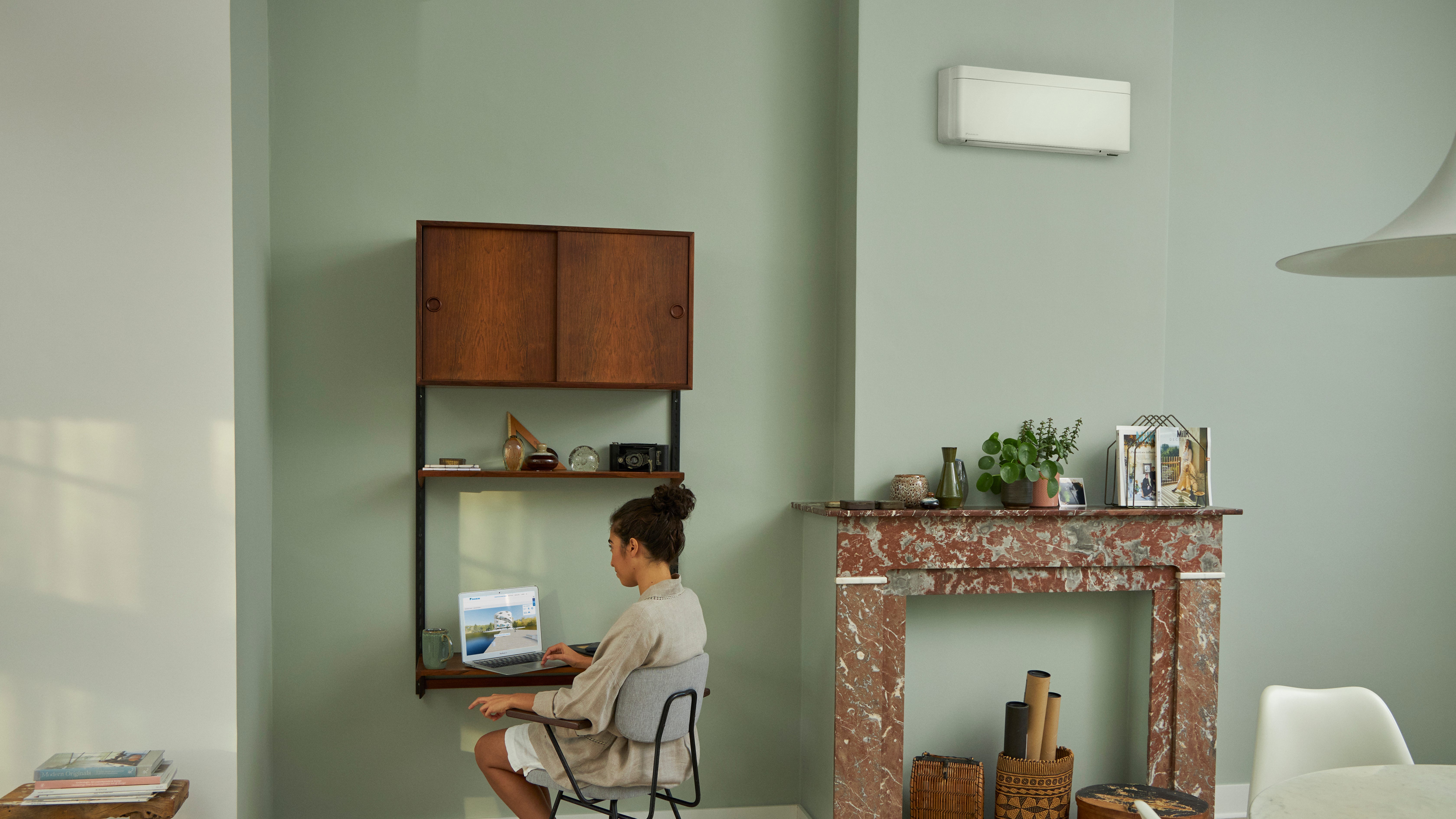 Visite du Centre d'expérience virtuelle Daikin via un ordinateur portable installé sur un petit bureau dans un salon joliment décoré.